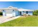 Charming single-story home with a well-manicured lawn and attached garage, painted in a lovely light blue hue at 3910 Cape Haze Dr, Rotonda West, FL 33947