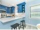 View of the white countertops, blue cabinets, and kitchen bar with seating at 3910 Cape Haze Dr, Rotonda West, FL 33947