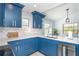 Bright modern kitchen with blue cabinets, herringbone backsplash, and stainless steel appliances at 3910 Cape Haze Dr, Rotonda West, FL 33947