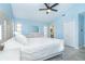 Light-filled main bedroom with a decorative mirror, fan and ensuite bathroom at 3910 Cape Haze Dr, Rotonda West, FL 33947