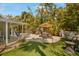 Landscaped backyard featuring a pool, patio with dining set, and lush tropical foliage creating a private outdoor oasis at 402 71St St, Holmes Beach, FL 34217