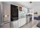 Modern kitchen with stainless steel appliances, white cabinets, and an open layout leading to the living area at 402 71St St, Holmes Beach, FL 34217