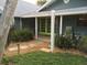 Charming outdoor patio with green doors offers relaxing spot with lush landscaping at 402 71St St, Holmes Beach, FL 34217