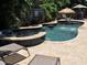 Outdoor pool area with water fountain feature and an in-ground spa on a stone patio at 402 71St St, Holmes Beach, FL 34217