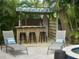 Fun poolside tiki bar with a surfboard and several seats, next to the pool and hot tub at 402 71St St, Holmes Beach, FL 34217