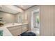 Well-lit bathroom featuring dual sinks, a door to the outside, and neutral decor at 4420 Oak View Dr, Sarasota, FL 34232
