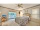 Cozy main bedroom with ceiling fan, plush carpet, serene view to the outdoors and sliding door to screen porch at 4420 Oak View Dr, Sarasota, FL 34232