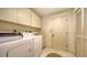 Functional laundry room with washer, dryer, storage cabinets, and a utility sink for convenience at 4420 Oak View Dr, Sarasota, FL 34232