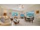 Inviting living room with large windows, tiled floors, comfortable seating, and access to the screened lanai at 4420 Oak View Dr, Sarasota, FL 34232