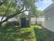 View of expansive backyard with included storage shed, landscaping, fencing, and mower at 4431 W Wallace Ave, Tampa, FL 33611