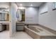 Modern bathroom featuring a soaking tub with stone surround, vanity, and sleek fixtures at 4662 Long Lake Dr, Sarasota, FL 34233