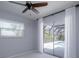 This bright bedroom features a ceiling fan and sliding glass doors to the pool area at 4662 Long Lake Dr, Sarasota, FL 34233