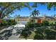 Inviting single-story home with a two-car garage, mature trees, manicured lawn, and vibrant landscaping at 4662 Long Lake Dr, Sarasota, FL 34233