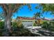 Charming single-story home with a two-car garage, manicured landscaping, and a bright yellow exterior at 4662 Long Lake Dr, Sarasota, FL 34233