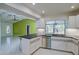 Bright kitchen featuring white cabinets, stainless steel appliances, and an open layout into the living area at 4662 Long Lake Dr, Sarasota, FL 34233
