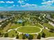 Expansive aerial view showcases the lush community park with various recreational amenities and green spaces at 4706 Balboa Park Loop, Bradenton, FL 34211