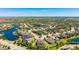 An aerial view of the home in a residential area near a lake with lush greenery and well-maintained yards at 4706 Balboa Park Loop, Bradenton, FL 34211