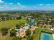 Aerial view features playground with blue canopies, tennis courts, and plenty of green space in the community at 4706 Balboa Park Loop, Bradenton, FL 34211