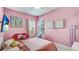 Whimsical pink bedroom featuring a hanging chair and playful decor at 4706 Balboa Park Loop, Bradenton, FL 34211
