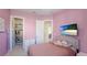 Pink bedroom with mounted TV and access to walk-in closet and bathroom at 4706 Balboa Park Loop, Bradenton, FL 34211