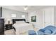 Bright bedroom with a queen bed, ceiling fan, carpet, and an accent chair and ottoman at 4706 Balboa Park Loop, Bradenton, FL 34211
