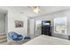 Bright, carpeted bedroom with a queen bed, ceiling fan, television, and an accent chair and ottoman at 4706 Balboa Park Loop, Bradenton, FL 34211