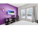 Bedroom with a bright purple accent wall, two windows, and a television on the wall for entertainment at 4706 Balboa Park Loop, Bradenton, FL 34211
