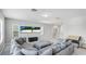 Bright living room with a large sectional sofa and ottoman facing a wall-mounted television at 4706 Balboa Park Loop, Bradenton, FL 34211