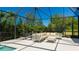 The screened-in patio features lounge seating and a beautiful view of the backyard at 4706 Balboa Park Loop, Bradenton, FL 34211