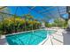 A stunning screened-in pool features sparkling turquoise water, heated spa, and basketball hoop at 4706 Balboa Park Loop, Bradenton, FL 34211