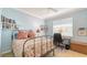 Cozy bedroom with comfortable bed, a window view, and shelving for displaying books and personal items at 4922 Commonwealth Dr, Sarasota, FL 34242