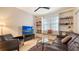 Cozy den featuring a TV, built-in shelving, and tile floors at 4922 Commonwealth Dr, Sarasota, FL 34242