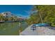Scenic waterfront view with a private dock, a calm canal, and lush tropical landscaping at 4922 Commonwealth Dr, Sarasota, FL 34242