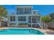Beautiful backyard with a pool, a white two-story house, a grill, and tropical landscaping at 4922 Commonwealth Dr, Sarasota, FL 34242