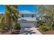 Charming two-story home with a two car garage, metal roof, and lush tropical landscaping at 4922 Commonwealth Dr, Sarasota, FL 34242