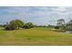 Scenic golf course view with green grass, water, and mature trees and landscaping at 5078 Marsh Field Rd # 82, Sarasota, FL 34235