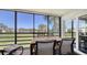 This screened lanai features a beautiful waterfront view with a patio table and chairs for outdoor dining at 5078 Marsh Field Rd # 82, Sarasota, FL 34235