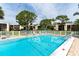 Community pool with clear blue water, surrounded by lounge chairs and lush greenery at 5078 Marsh Field Rd # 82, Sarasota, FL 34235