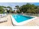 Community pool with clear blue water, surrounded by lounge chairs and lush greenery at 5078 Marsh Field Rd # 82, Sarasota, FL 34235
