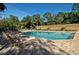 Community pool with clear blue water, surrounded by lounge chairs and mature trees at 5078 Marsh Field Rd # 82, Sarasota, FL 34235