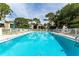 Community swimming pool and lounge area with chairs and mature trees at 5078 Marsh Field Rd # 82, Sarasota, FL 34235