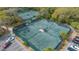 Aerial view of tennis courts in a community surrounded by trees and greenery at 5078 Marsh Field Rd # 82, Sarasota, FL 34235