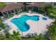 Aerial view of a community pool with a unique shape, surrounded by lush landscaping and comfortable seating at 510 16Th E Ave, Palmetto, FL 34221