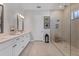 Well-lit bathroom features double vanity, quartz counters, framed mirrors, and large glass shower at 510 16Th E Ave, Palmetto, FL 34221