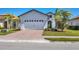 Inviting home featuring a two-car garage, brick driveway, and lush landscaping for enhanced curb appeal at 510 16Th E Ave, Palmetto, FL 34221