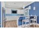 Stylish kitchenette featuring modern stainless steel appliances, white cabinetry, bar seating, and blue tile backsplash at 510 16Th E Ave, Palmetto, FL 34221