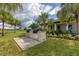 Outdoor kitchen with built-in grill and counter space, set in a landscaped backyard with palm trees at 510 16Th E Ave, Palmetto, FL 34221