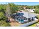 This home features a screened pool and a backyard surrounded by mature trees and a privacy fence at 5330 Alseir Rd, North Port, FL 34288