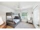Bright bedroom with a large window, ceiling fan, and gray bunk bed, providing a comfortable living space at 5330 Alseir Rd, North Port, FL 34288