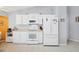 Well-lit kitchen featuring white cabinets, white appliances, and neutral countertops at 5330 Alseir Rd, North Port, FL 34288